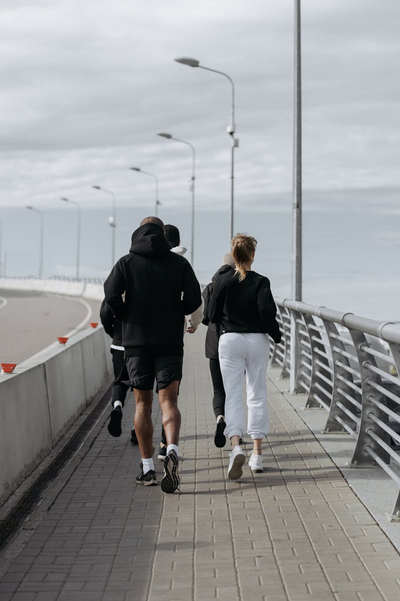 A People doing Jogging on the Sidewalk